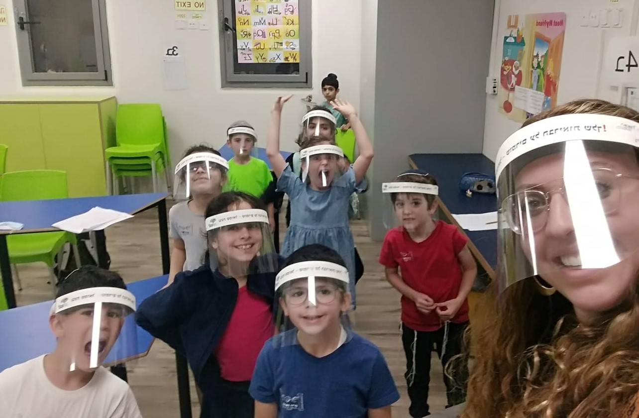 תמונה של מורה ותלמידים עוטים מסכות מיגון נגד קורונה