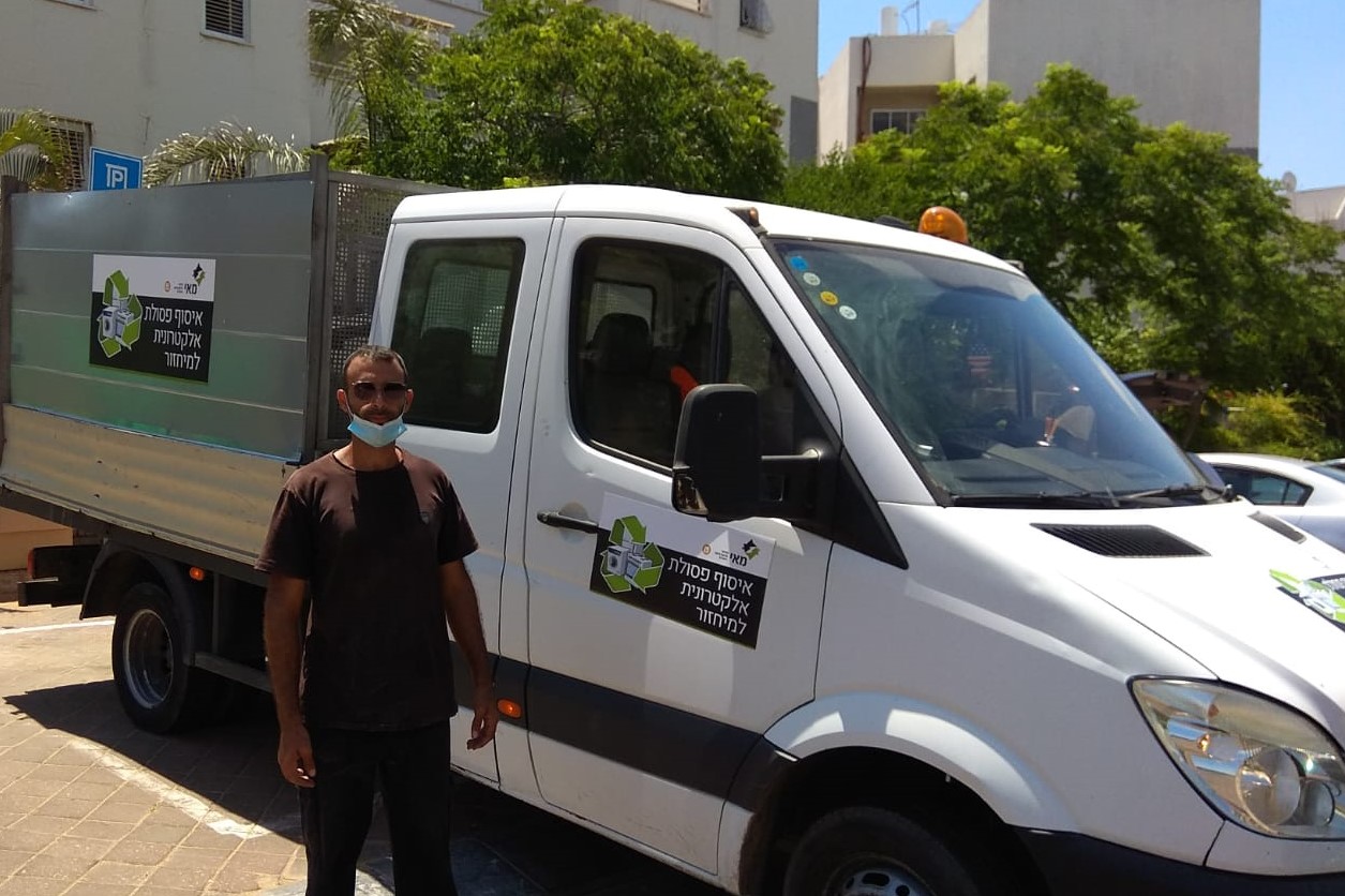 צילום של אדם עומד לפני טנדר בצבע לבן