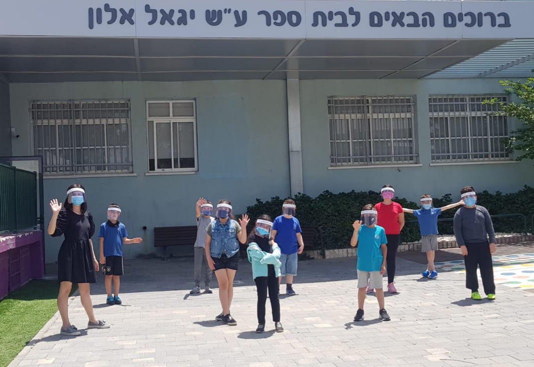 תלמידים עומדים בחזית בית הספר