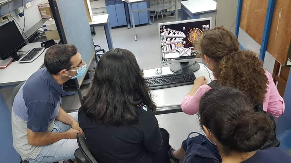 קבוצת בנות ומדריך בבגדי מיגון מפעילים מחשב