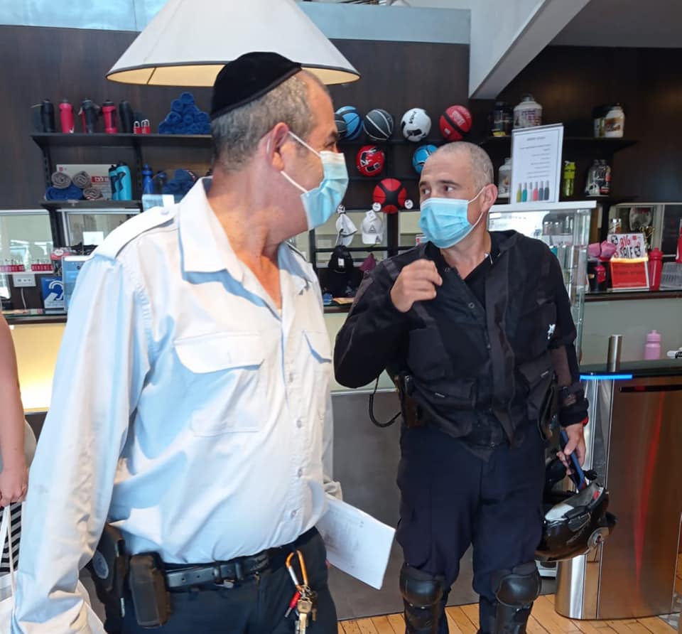 פקחים עוטי מסכות באכיפה בתוך חנות