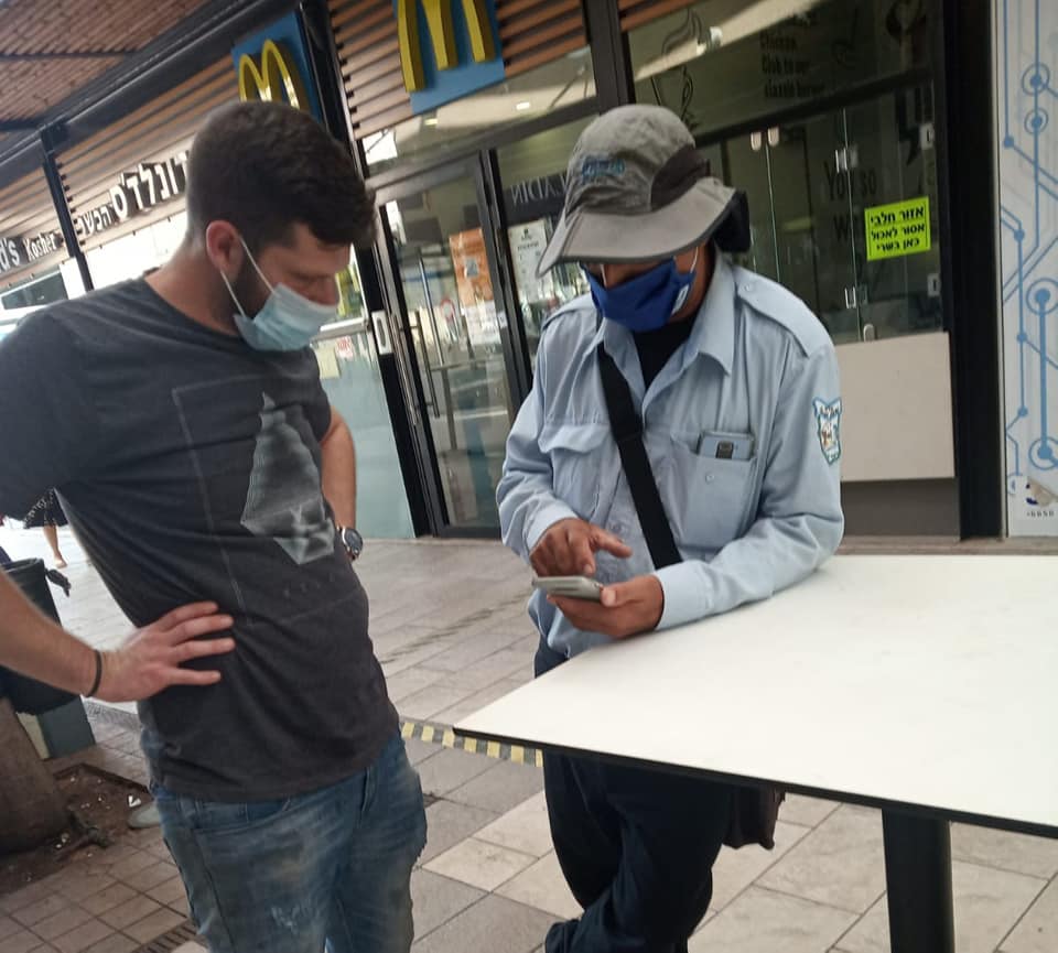 פקח בשיחה עם תושב ברחוב