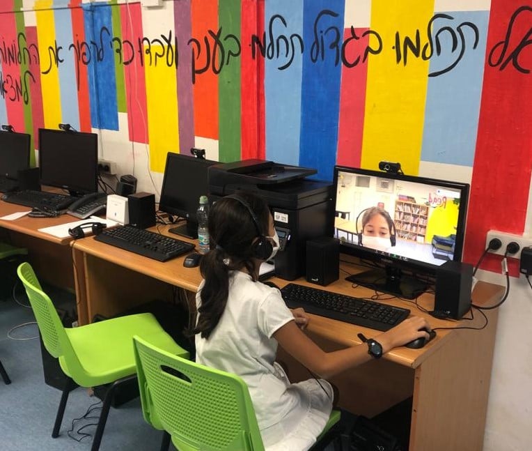 תלמידה יושבת מול מחשב 