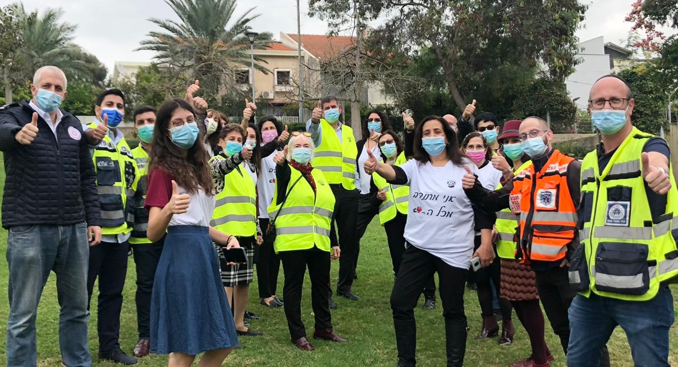 מתנדבי גבעת שמואל עם וסטים זוהרים עוטים מסכות